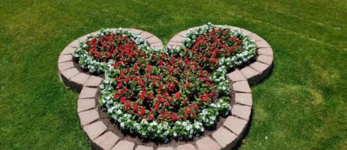 Round-lobed flower bed of red and white flowers edged with curved block